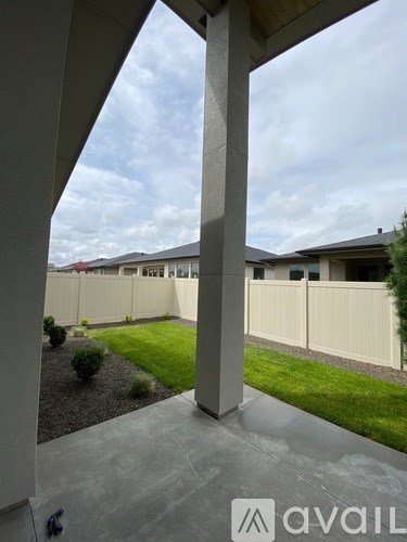A view from a covered walkway looking out to a row of houses.