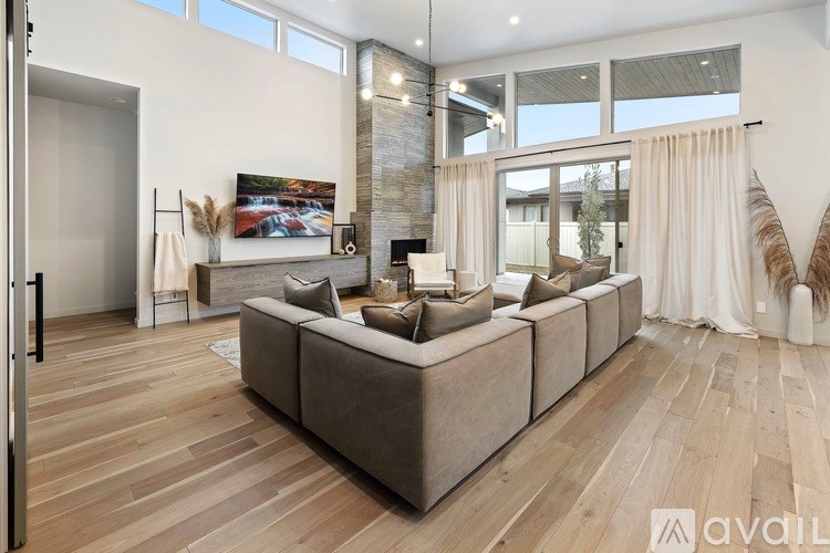 A modern living room with a large sectional sofa and a fireplace.