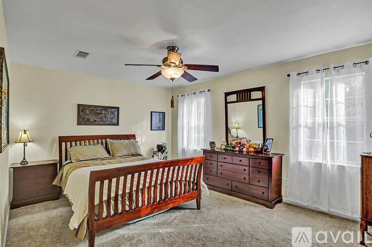 A bedroom with a bed, dresser, and mirror.