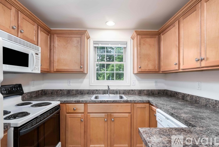 A kitchen with wooden cabinets and granite countertops.