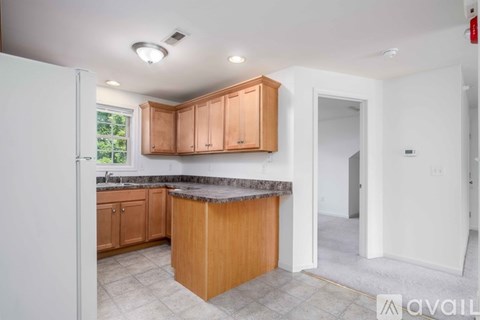 A kitchen with wooden cabinets and a granite countertop.
