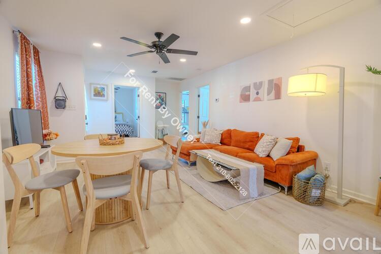 A living room with a sofa, a bar stool, and a television.