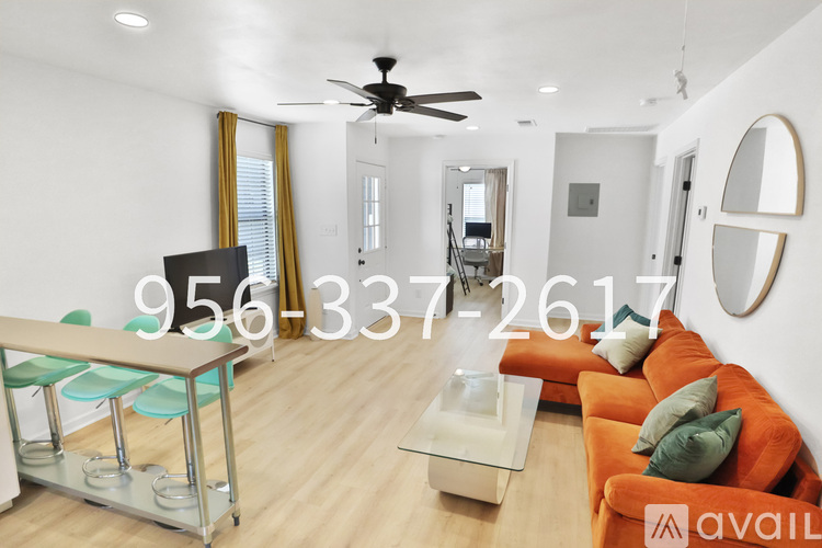 A living room with a television, a sofa, and a glass coffee table.