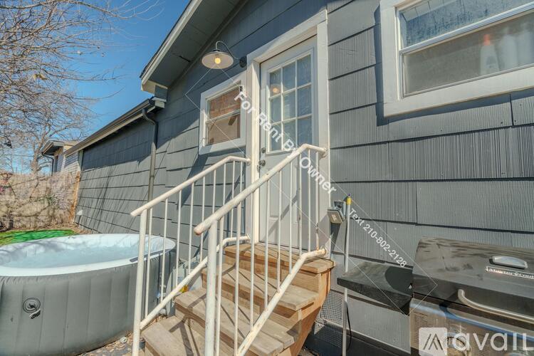 A house with a hot tub and stairs leading to a door.