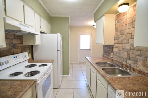 A kitchen with a white stove and a white refrigerator.