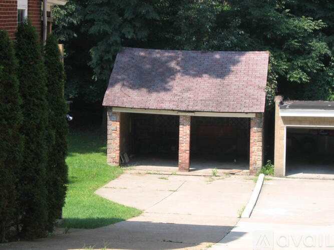 A small building with a brick pillar and a tiled roof.
