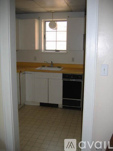 A kitchen with white cabinets and a black dishwasher.