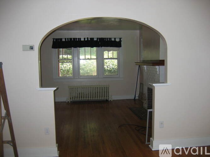 A room with a window and a radiator on the floor.