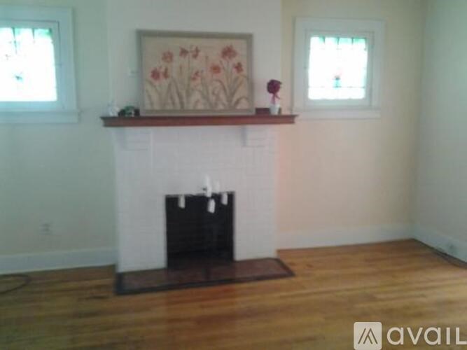 A fireplace with a painting above it in a room.