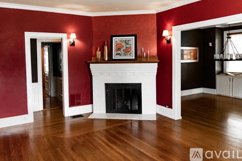A living room with a fireplace and a painting above it.