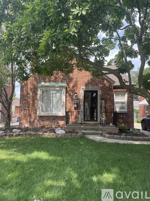 A brick house with a tree in front.