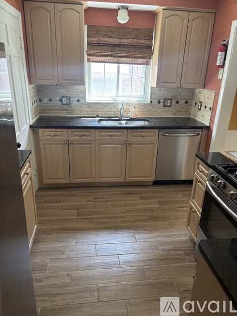 A kitchen with wooden cabinets and a black countertop.