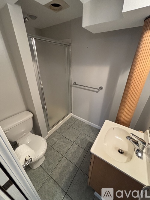 A bathroom with a toilet, sink, and shower.