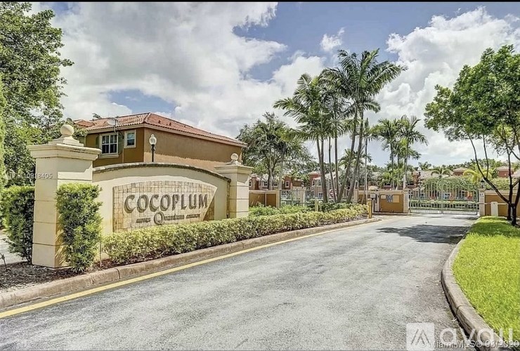 The image shows a signboard of Cocoplum with a building behind it.