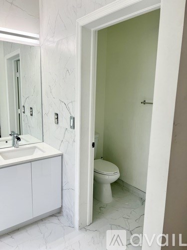 A white bathroom with a toilet and sink.