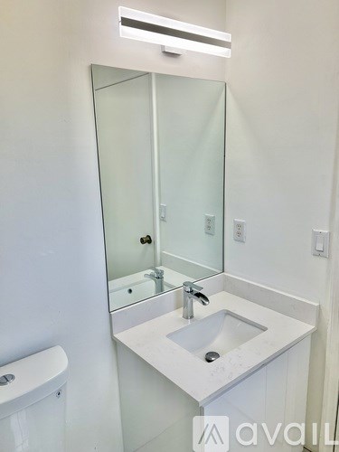 A white sink in a bathroom with a glass door medicine cabinet.