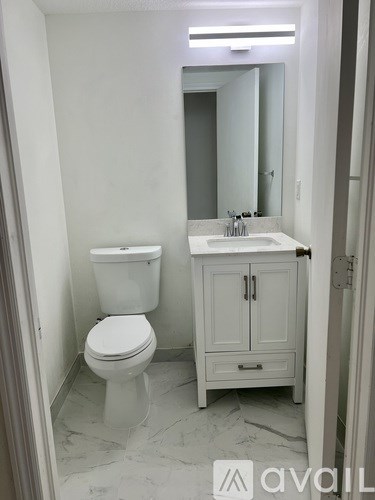 A white toilet and sink in a bathroom.