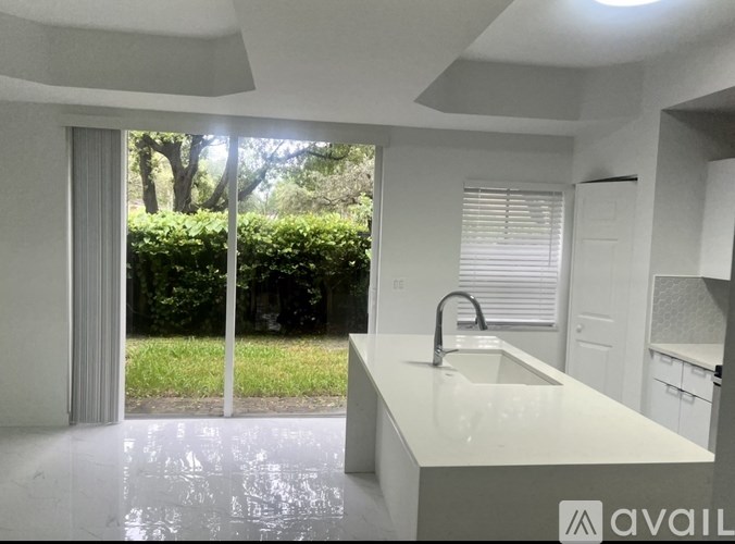 A modern kitchen with a white countertop and a sink.