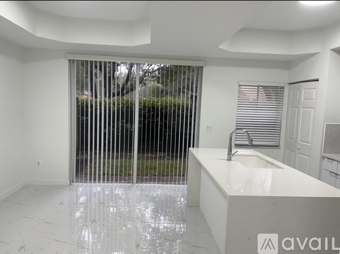 A bathroom with a marble countertop and a window with blinds.