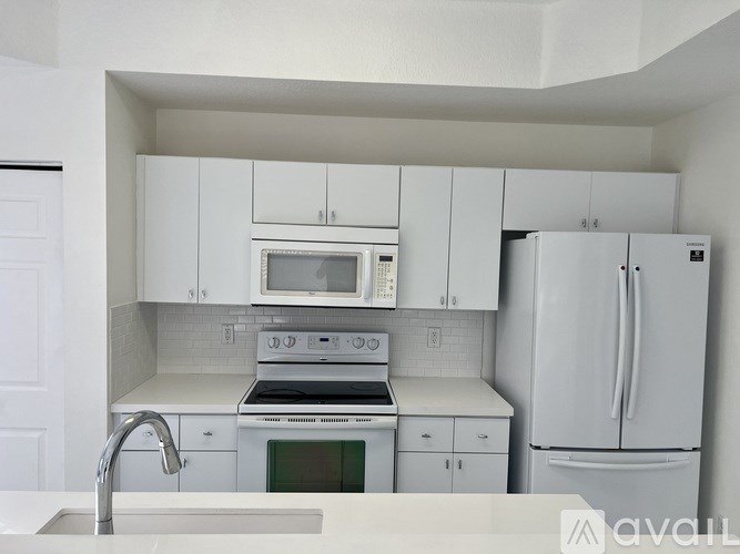 A kitchen with white cabinets and appliances.