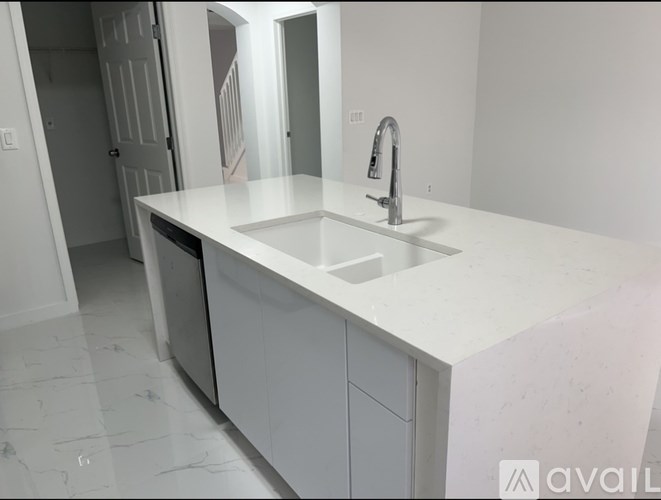 A white kitchen with a sink and a dishwasher.