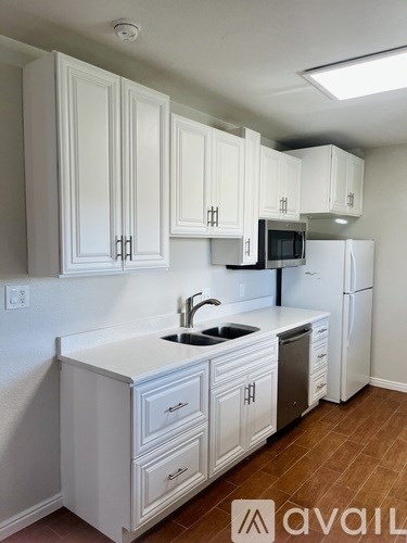 A kitchen with white cabinets and a white counter top.