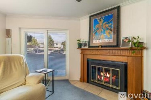 A living room with a fireplace and a painting on the wall.