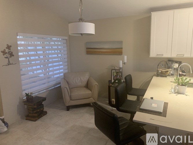 A modern kitchen with a dining area and two chairs.