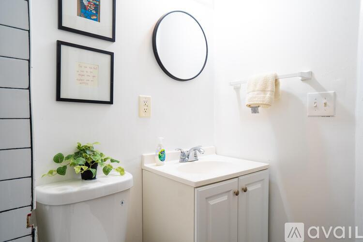 A bathroom with a white sink and a white cabinet.
