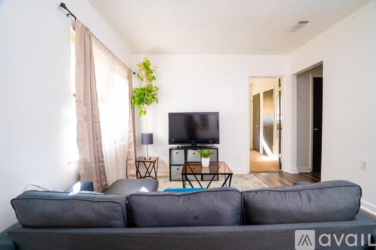 A living room with a grey couch and a flat screen TV.
