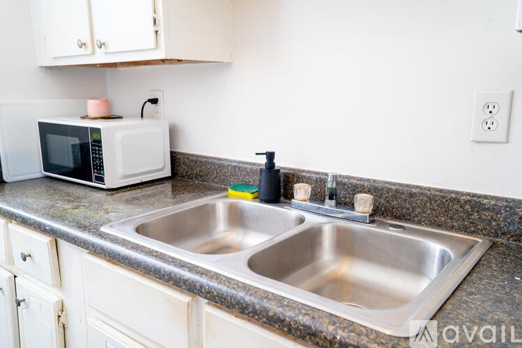 A kitchen with a sink and a microwave on the counter.