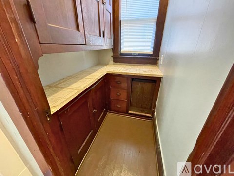 A kitchen with wooden cabinets and a window.