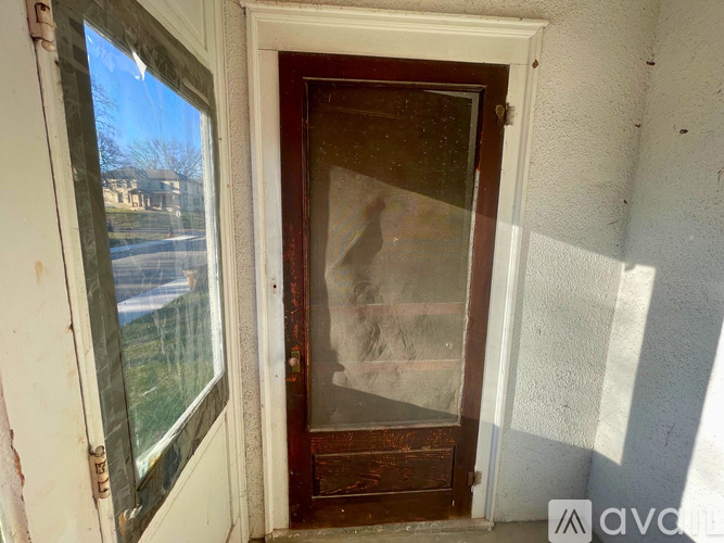 A person is standing in a doorway with a window on the left.