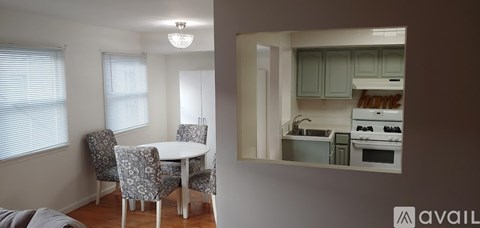 A kitchen with a dining table and chairs is reflected in a mirror.