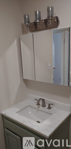 A bathroom with a sink and a mirror above it.