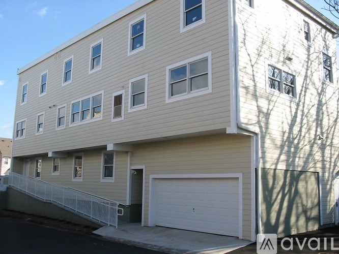 A two-story building with a garage door is available for rent.