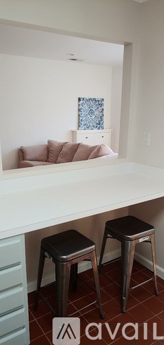 Two black stools are placed in front of a white counter.