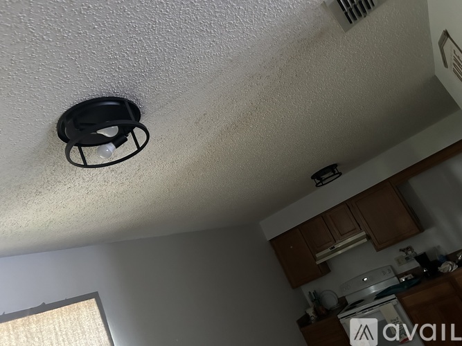 A smoke detector is mounted on the ceiling in a kitchen.