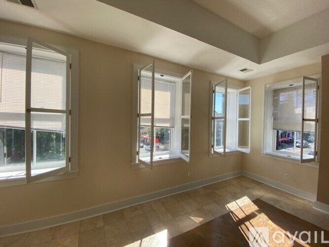 A room with three windows and a tiled floor.