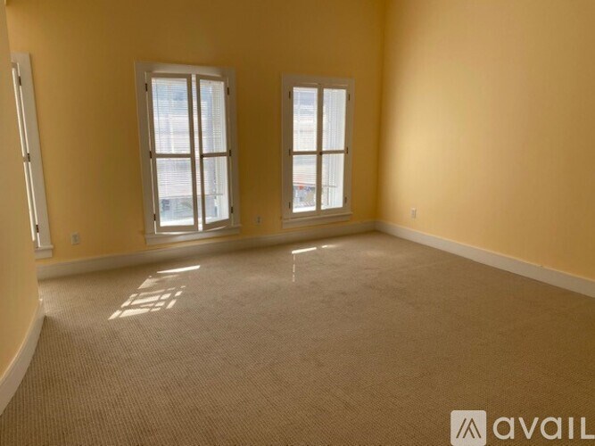 A room with two windows and a carpeted floor.