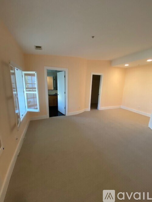 A spacious empty room with a door and a window.