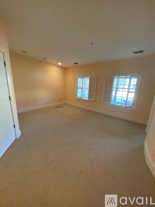 A large empty room with two windows.