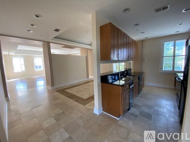 A kitchen with brown cabinets and a black countertop is available for rent.