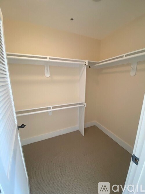 A white closet with shelves and a door.