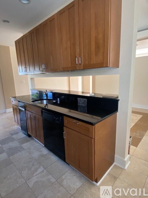 A kitchen with wooden cabinets and black countertops.