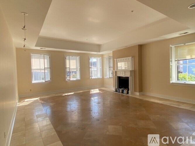 A spacious living room with a fireplace and large windows.
