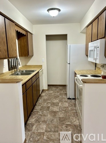 A kitchen with brown cabinets and a white fridge.