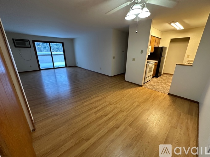 A spacious room with wooden flooring and a ceiling fan.
