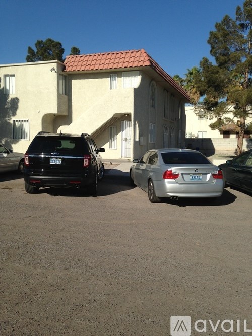 Two cars parked in front of a house with a sign that says "available".