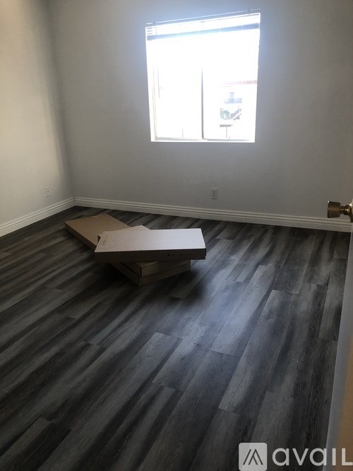 A room with wooden flooring and a window.